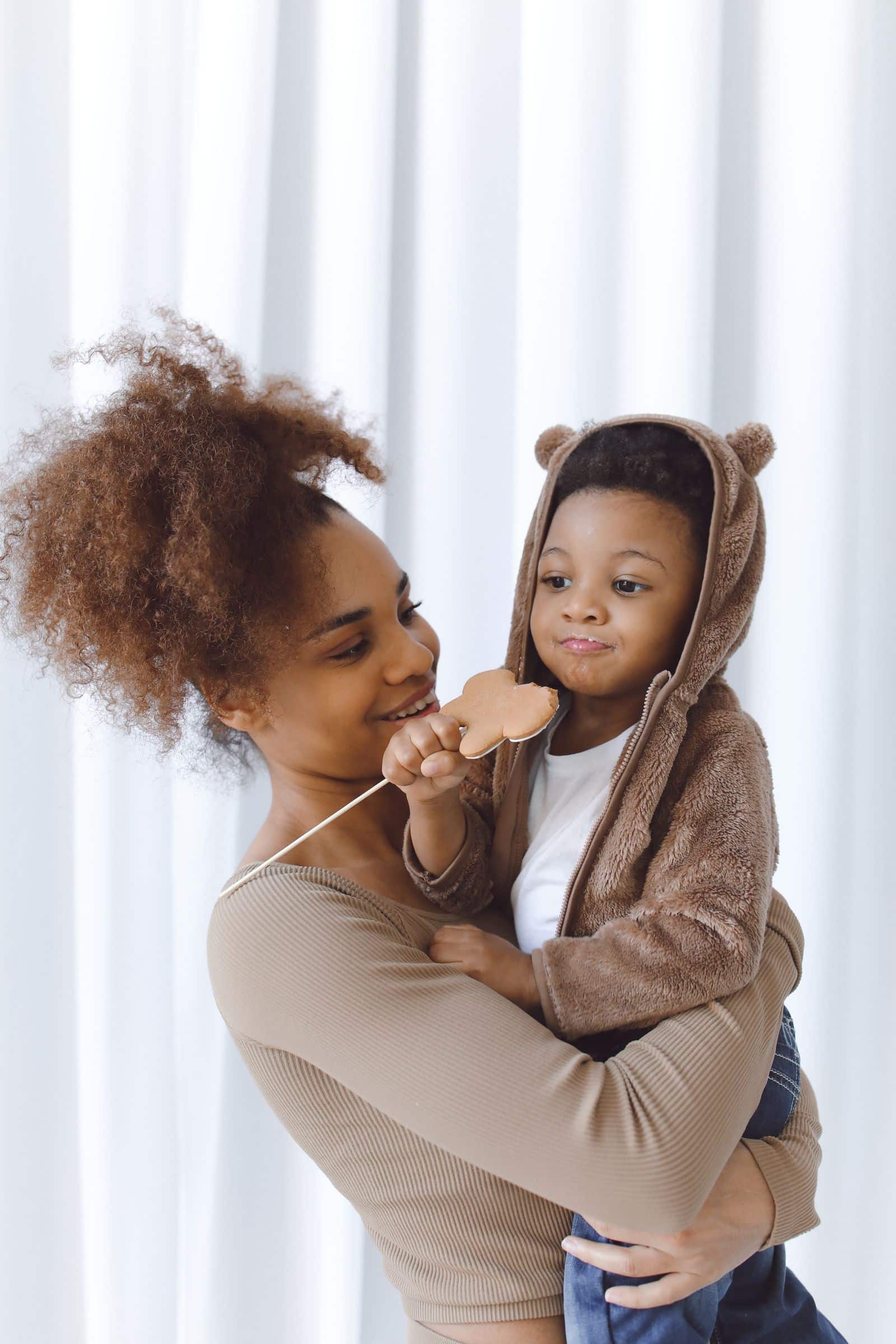 Femme souriante portant un jeune enfant dans ses bras