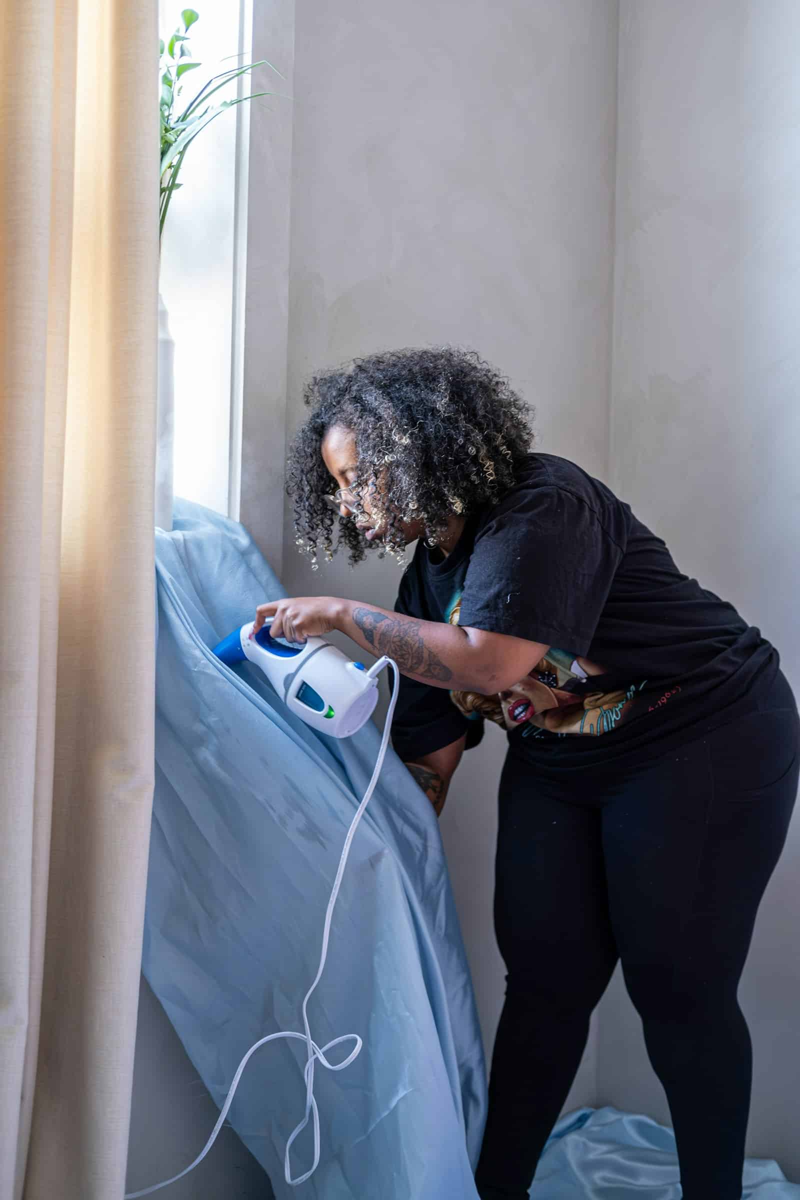 Femme défroissant un drap au défroisseur vapeur