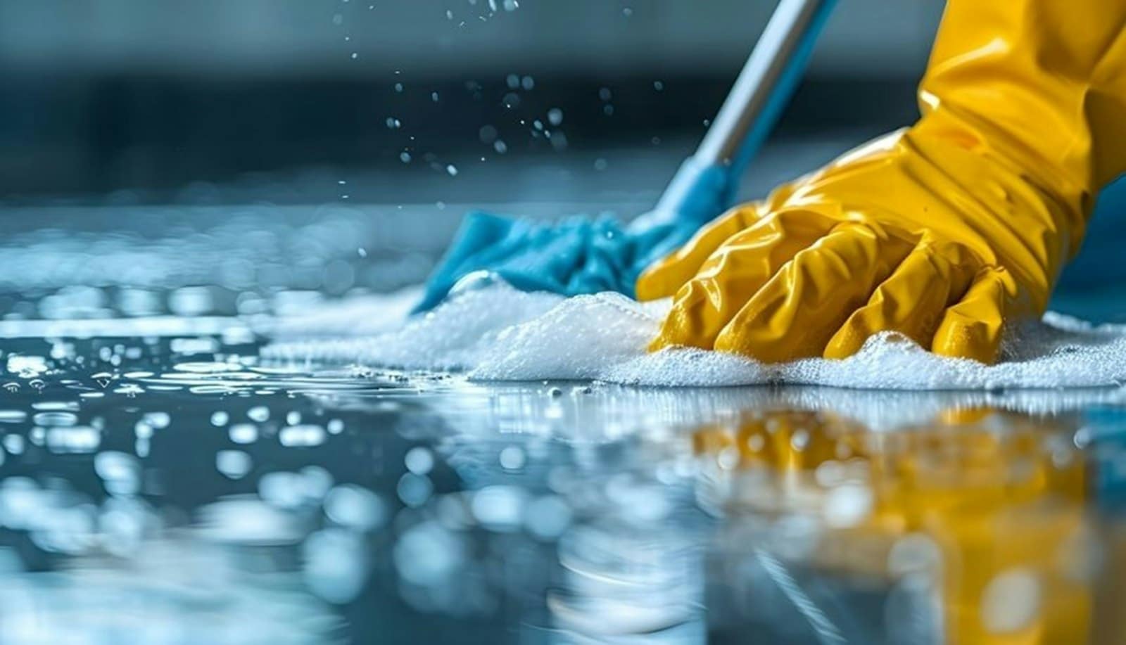 Nettoyage d’un sol à la mousse avec des gants de protection